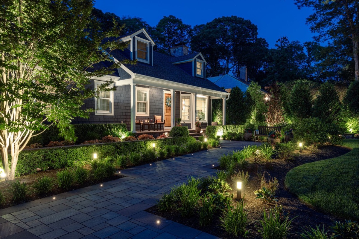 Lit paver walkway and plantings at dusk